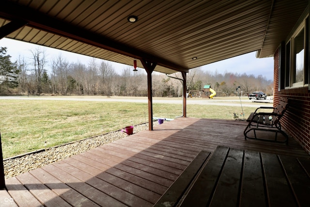 wooden deck with a playground and a yard