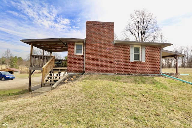 back of property with stairway, a yard, a chimney, a deck, and brick siding