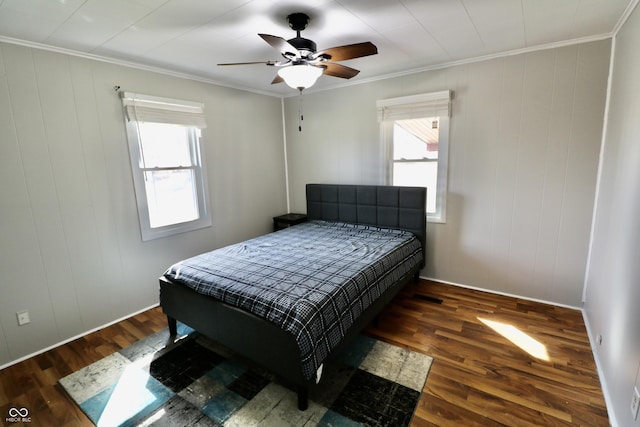 bedroom with multiple windows, wood finished floors, and ornamental molding