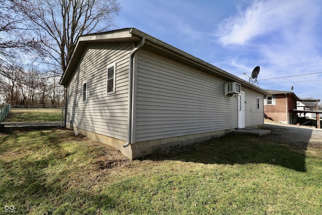 view of side of property with a yard, fence, and a wall mounted AC