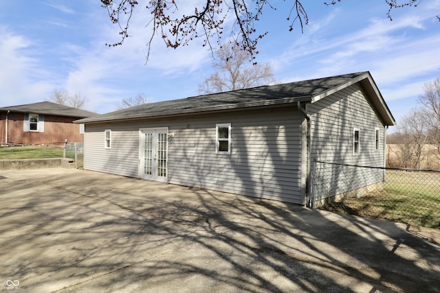 view of home's exterior with french doors, a patio, and fence