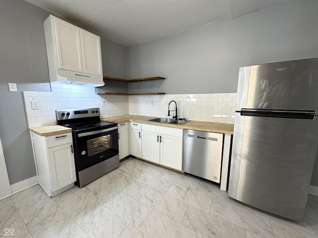 kitchen featuring open shelves, under cabinet range hood, appliances with stainless steel finishes, marble finish floor, and butcher block counters