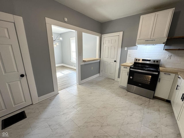 kitchen with stainless steel electric stove, visible vents, marble finish floor, and under cabinet range hood