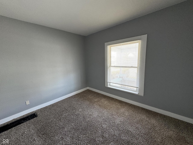 spare room featuring baseboards and carpet floors