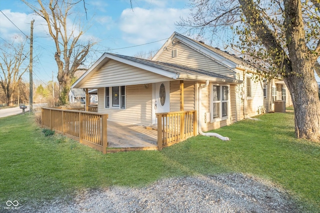 view of side of property featuring central air condition unit, a lawn, a porch, and a shingled roof