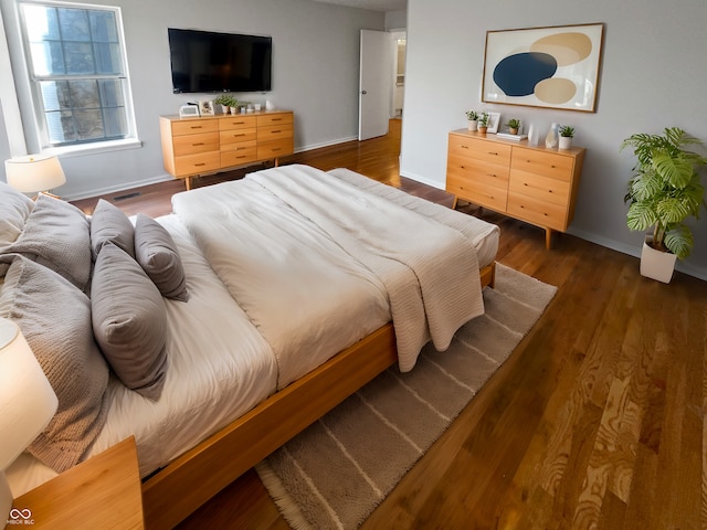 bedroom featuring baseboards and wood finished floors