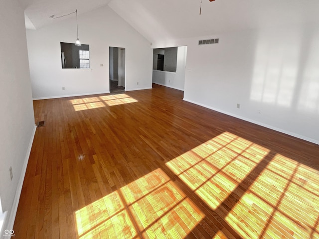 unfurnished room featuring a ceiling fan, visible vents, baseboards, high vaulted ceiling, and wood-type flooring