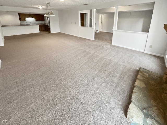 unfurnished living room with baseboards, carpet, and a textured ceiling