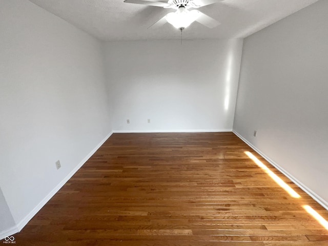 unfurnished room featuring baseboards, wood finished floors, and a ceiling fan