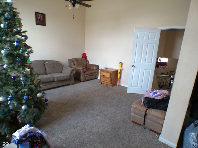 carpeted living room with baseboards and a ceiling fan