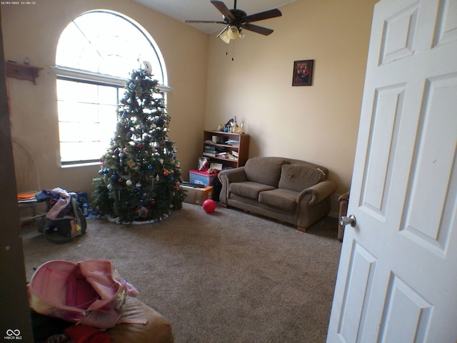 carpeted living room featuring a ceiling fan