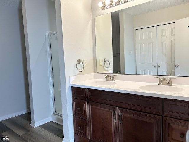 bathroom with double vanity, a stall shower, and a sink