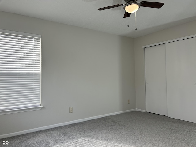 unfurnished bedroom with a ceiling fan, carpet flooring, baseboards, and a closet