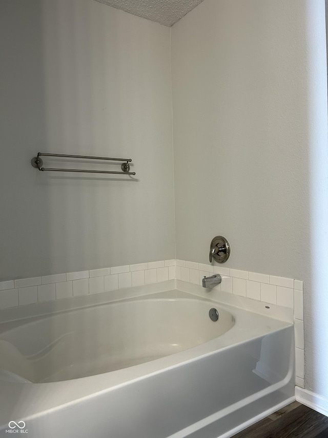 full bath with a bath and a textured ceiling