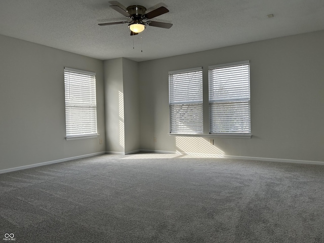 carpeted spare room with baseboards, a textured ceiling, and a ceiling fan