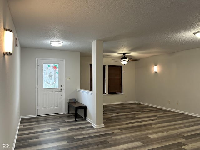 foyer with a textured ceiling, baseboards, a ceiling fan, and wood finished floors