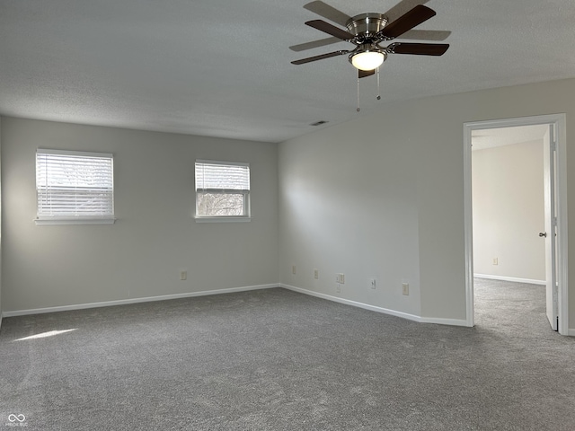 carpeted empty room with baseboards, visible vents, a textured ceiling, and ceiling fan