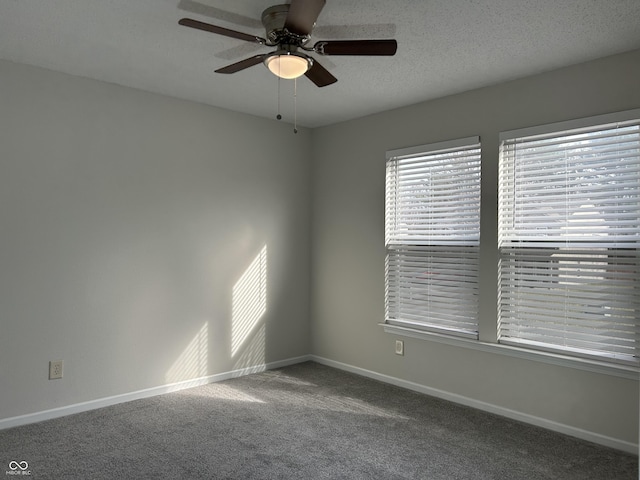 carpeted spare room with baseboards, a textured ceiling, and ceiling fan