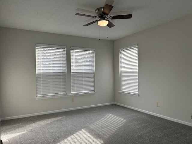 empty room with carpet flooring, a textured ceiling, baseboards, and a ceiling fan