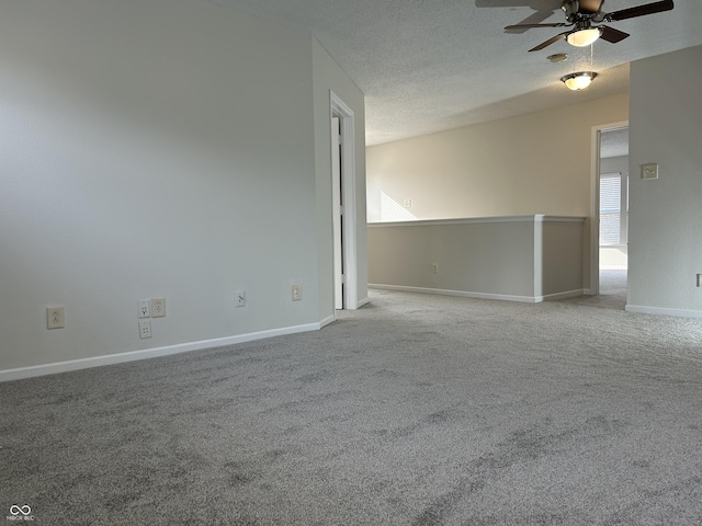 carpeted spare room with baseboards, a textured ceiling, and a ceiling fan