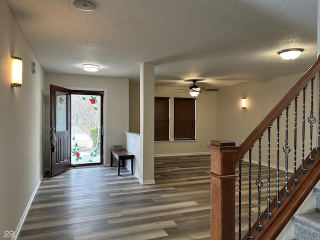 foyer featuring stairway, baseboards, dark wood-type flooring, and ceiling fan