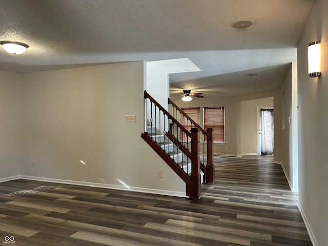 stairway with a textured ceiling, baseboards, a ceiling fan, and wood finished floors