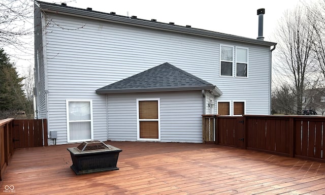 rear view of house featuring a shingled roof, a deck, and an outdoor fire pit