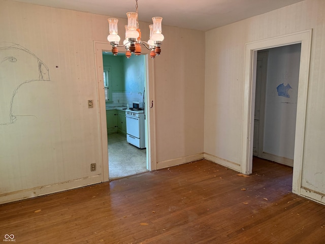 unfurnished dining area with an inviting chandelier and hardwood / wood-style floors