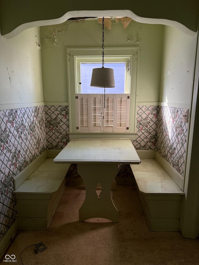 unfurnished dining area featuring tile walls and a wainscoted wall