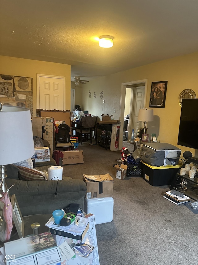 carpeted living area with a ceiling fan