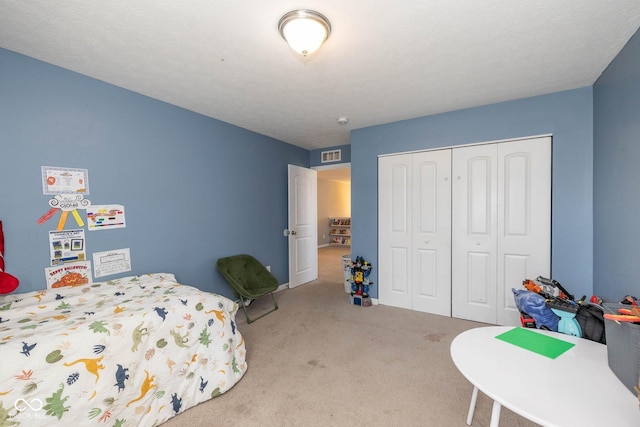 bedroom with visible vents, carpet, and a closet