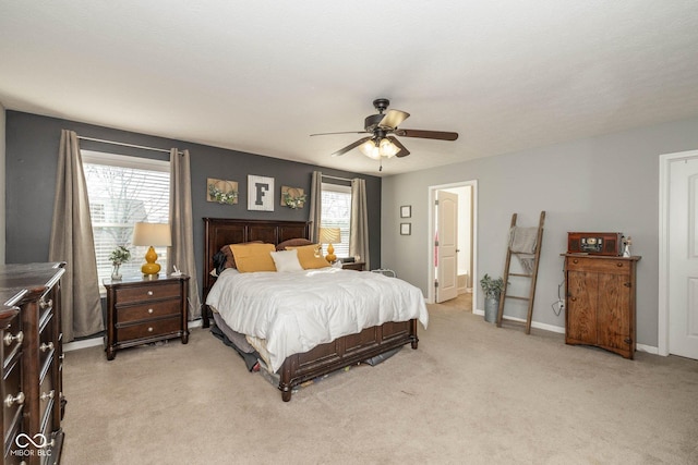 bedroom with multiple windows, light colored carpet, baseboards, and ceiling fan