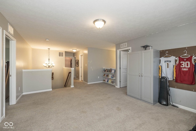 interior space featuring visible vents, baseboards, light colored carpet, a notable chandelier, and a textured ceiling