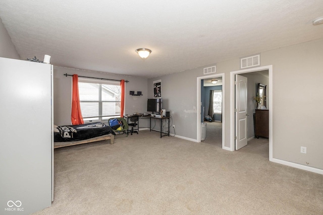 bedroom with light carpet, visible vents, and baseboards