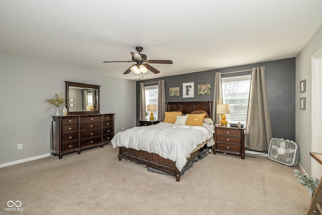 carpeted bedroom featuring baseboards and a ceiling fan