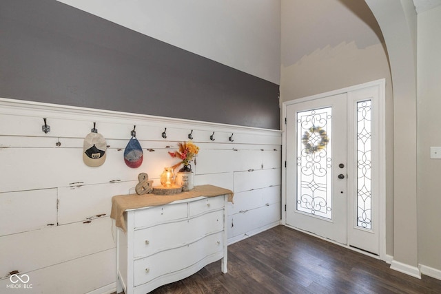 mudroom with dark wood finished floors and arched walkways