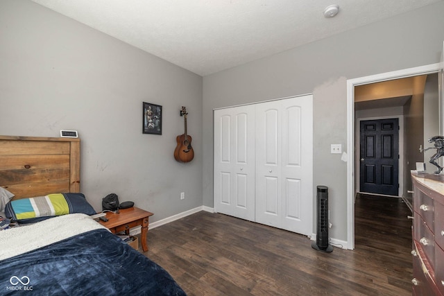 bedroom featuring dark wood-style floors, baseboards, and a closet