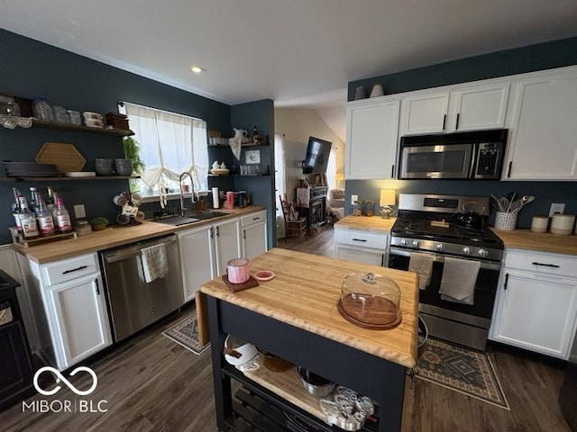 kitchen featuring a sink, open shelves, appliances with stainless steel finishes, and wooden counters