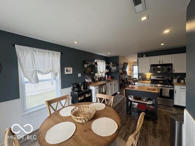 dining area with recessed lighting, visible vents, dark wood finished floors, and wainscoting