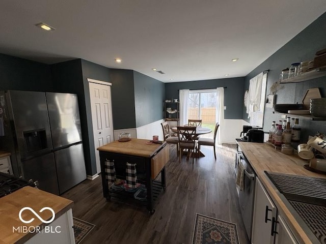 kitchen with butcher block countertops, appliances with stainless steel finishes, recessed lighting, and dark wood-style flooring