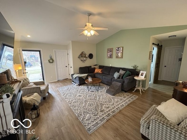 living room with lofted ceiling, wood finished floors, baseboards, and ceiling fan