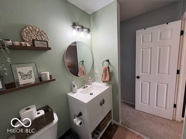 bathroom featuring vanity, toilet, and baseboards