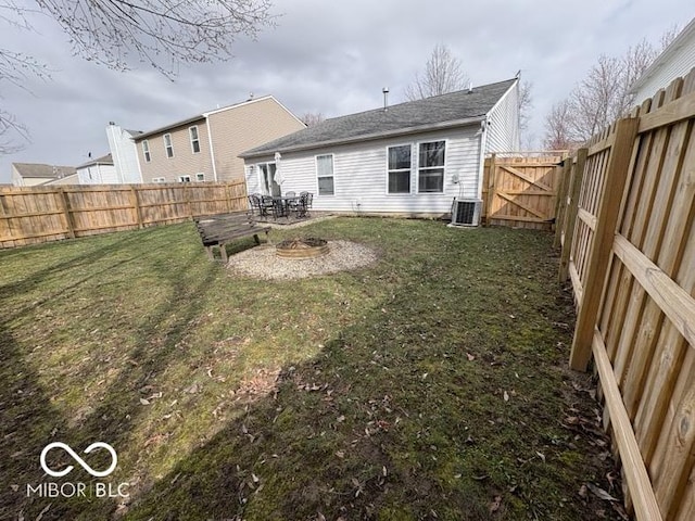 back of house with a fenced backyard, central AC, a yard, and a gate