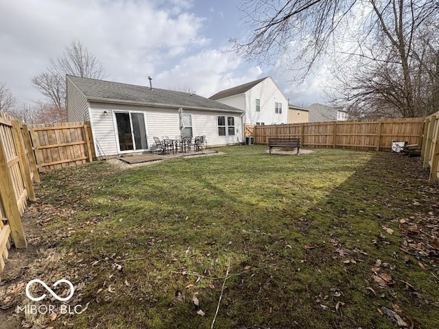 back of property featuring a yard, a fenced backyard, and a patio area