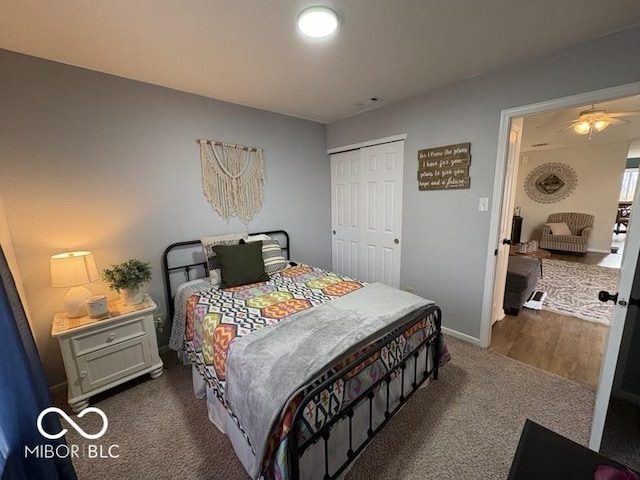 bedroom with a closet, dark carpet, and baseboards