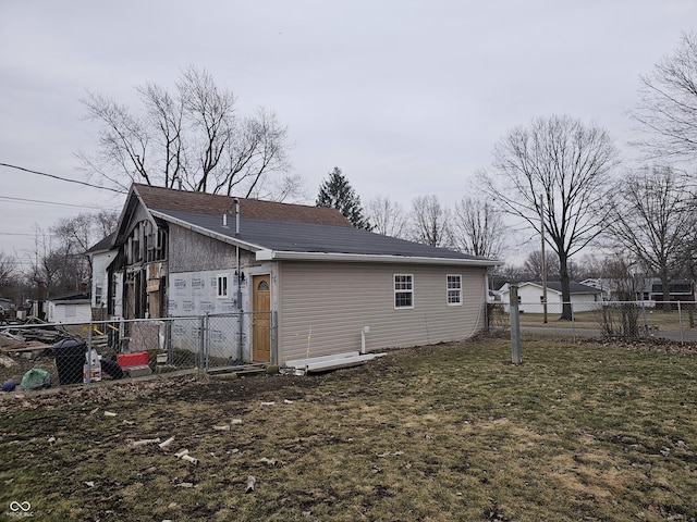 view of side of property with a lawn and fence