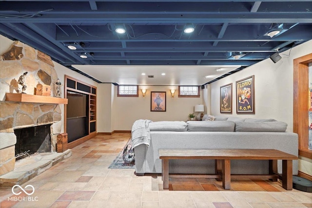 bedroom with stone finish flooring, baseboards, and a stone fireplace