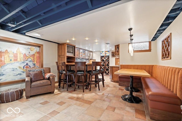 dining space featuring recessed lighting, bar, and stone finish floor