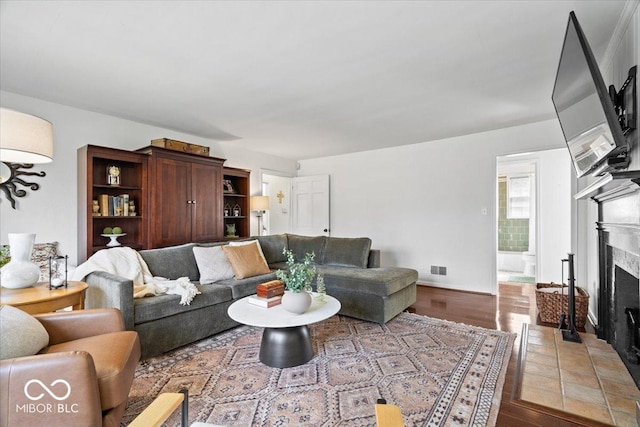 living room with a fireplace with flush hearth and wood finished floors