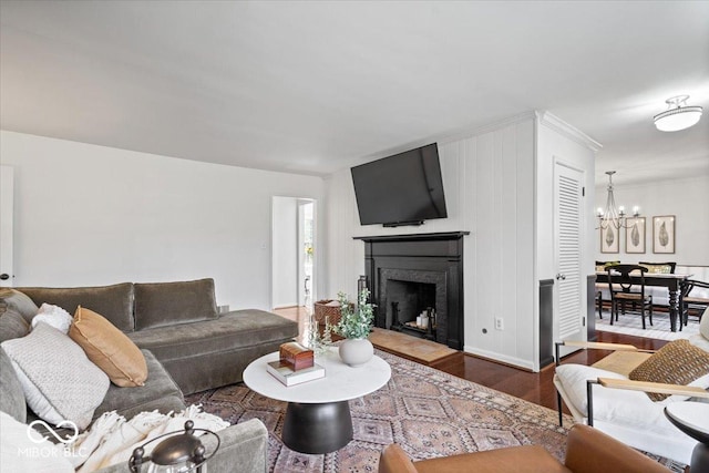 living room with a fireplace with flush hearth, an inviting chandelier, and wood finished floors